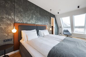 A modern bedroom with a large bed, a chair, and a view of the sky through a window. - Dünenloft, House Kliff Whg. 12 - Dünenlofts (Sylt)