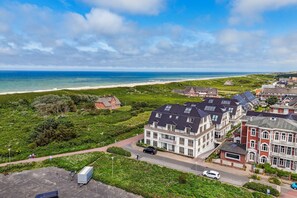 A coastal residential area with houses, a beach, and a clear sky. - Dünenloft, House Kliff Whg. 12 - Dünenlofts (Sylt)