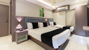 A modern hotel room with a large bed, bedside tables, a ceiling fan, and an air conditioning unit.