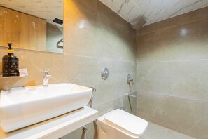 Een douche, handdoeken, zeep, toiletpapier