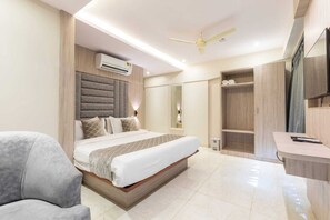 Une chambre moderne avec un grand lit, un bureau et une armoire.