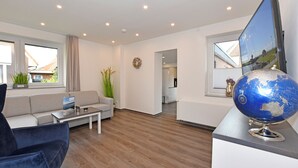 En moderne stue med sofa, sofabord og en globus på fod.