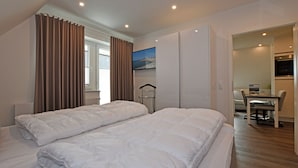 Een hotelkamer met twee bedden, een bureau en een stoel.