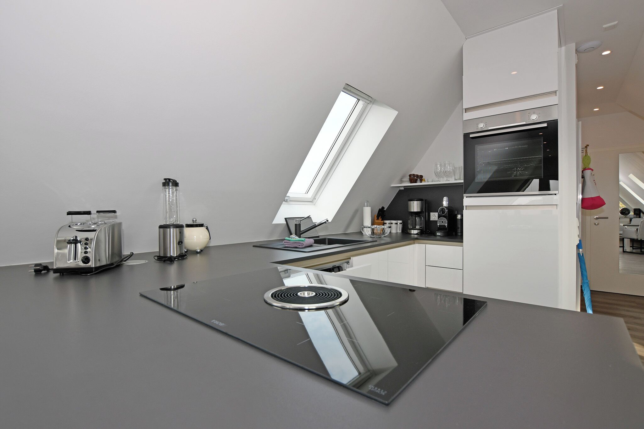 Una cucina moderna con piano cottura integrato, un tostapane e una macchina per il caffè.