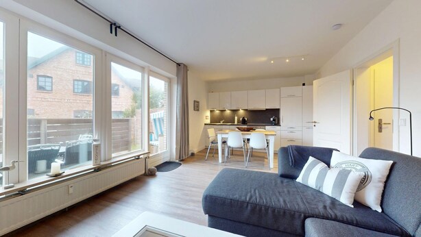 Un apartamento moderno con cocina, comedor y sala de estar con sofá.