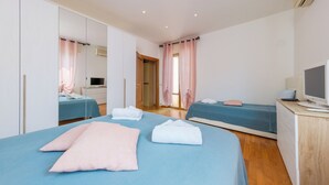 Un dormitorio con dos camas, un escritorio, un televisor y un armario.