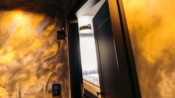 A room with a bed, a door, and a wall with a textured pattern.