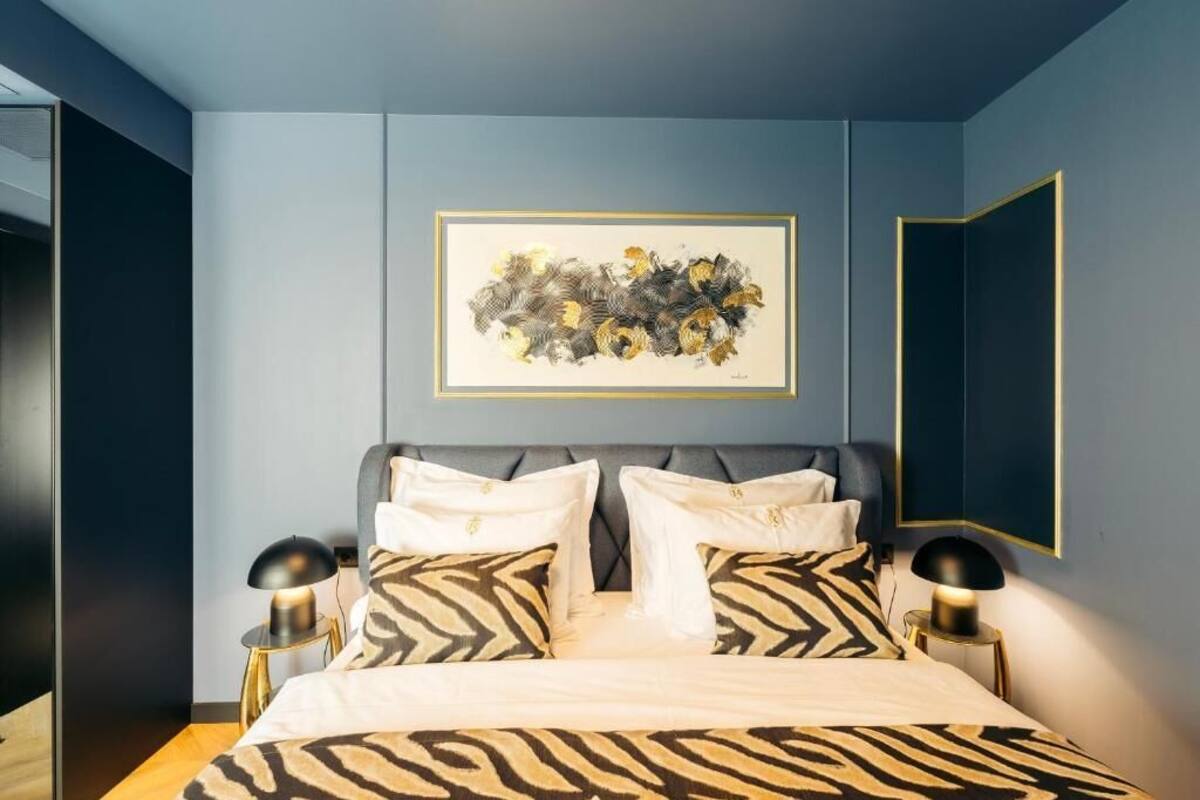 Ein modernes Schlafzimmer mit einem Bett, einem gerahmten abstrakten Gemälde und einem Spiegel.