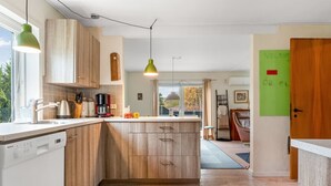 Een moderne keuken met houten kasten, een vast geïntegreerd eiland en hanglampen.