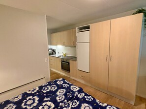 A compact room with a bed, a kitchenette, and a wardrobe. - 4 Person Holiday Home in Nexo (Nexø)