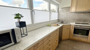 Una cocina moderna con un amplio ventanal, un microondas, un fregadero y una estufa.