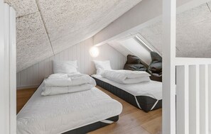 A bedroom with two beds, a sloped ceiling, and a skylight. - Nice home in Glesborg with sauna (Glesborg)