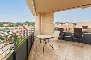 Ein Balkon mit Tisch und Stühlen und Blick auf die Stadt, außerdem ein Fliesenboden.