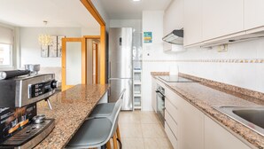Een moderne keuken met granieten werkbladen, roestvrijstalen apparatuur en een inbouwoven.