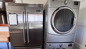 A stainless steel Viking refrigerator and a front-loading washing machine in a kitchen.