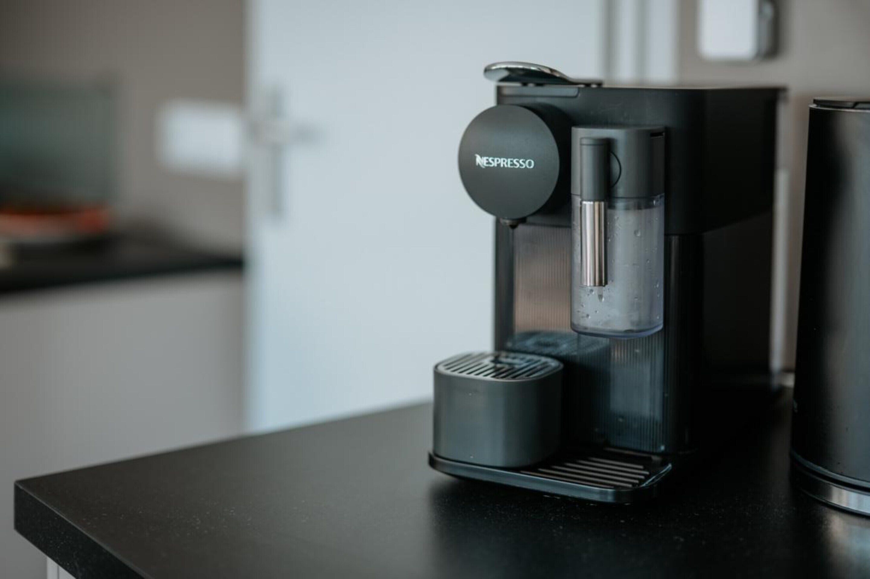 Une machine à café Nespresso posée sur un plan de travail de cuisine.