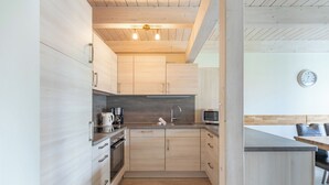 A modern kitchen with wooden cabinets, a built-in oven, a microwave, and a sink. - Vacation home "Fischerhuus" in Dagebüll for up to 7 people (Dagebüll)