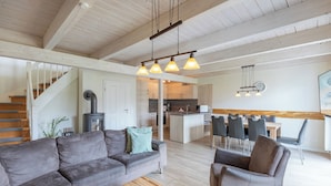 A modern living room with a gray sofa, a wooden coffee table, and a dining area with a wooden table and chairs. - Vacation home "Fischerhuus" in Dagebüll for up to 7 people (Dagebüll)