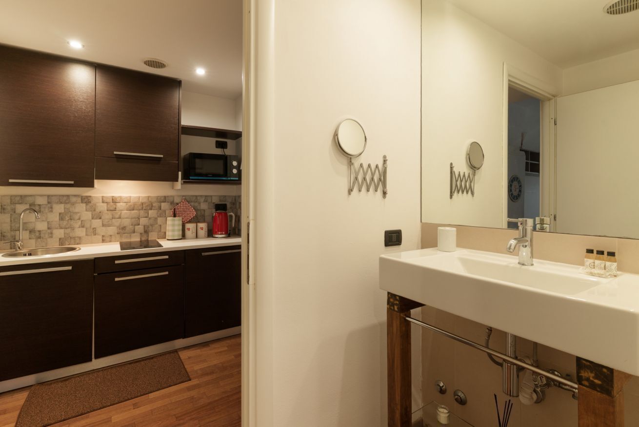 Una cocina moderna con armarios oscuros, un microondas y un lavamanos.