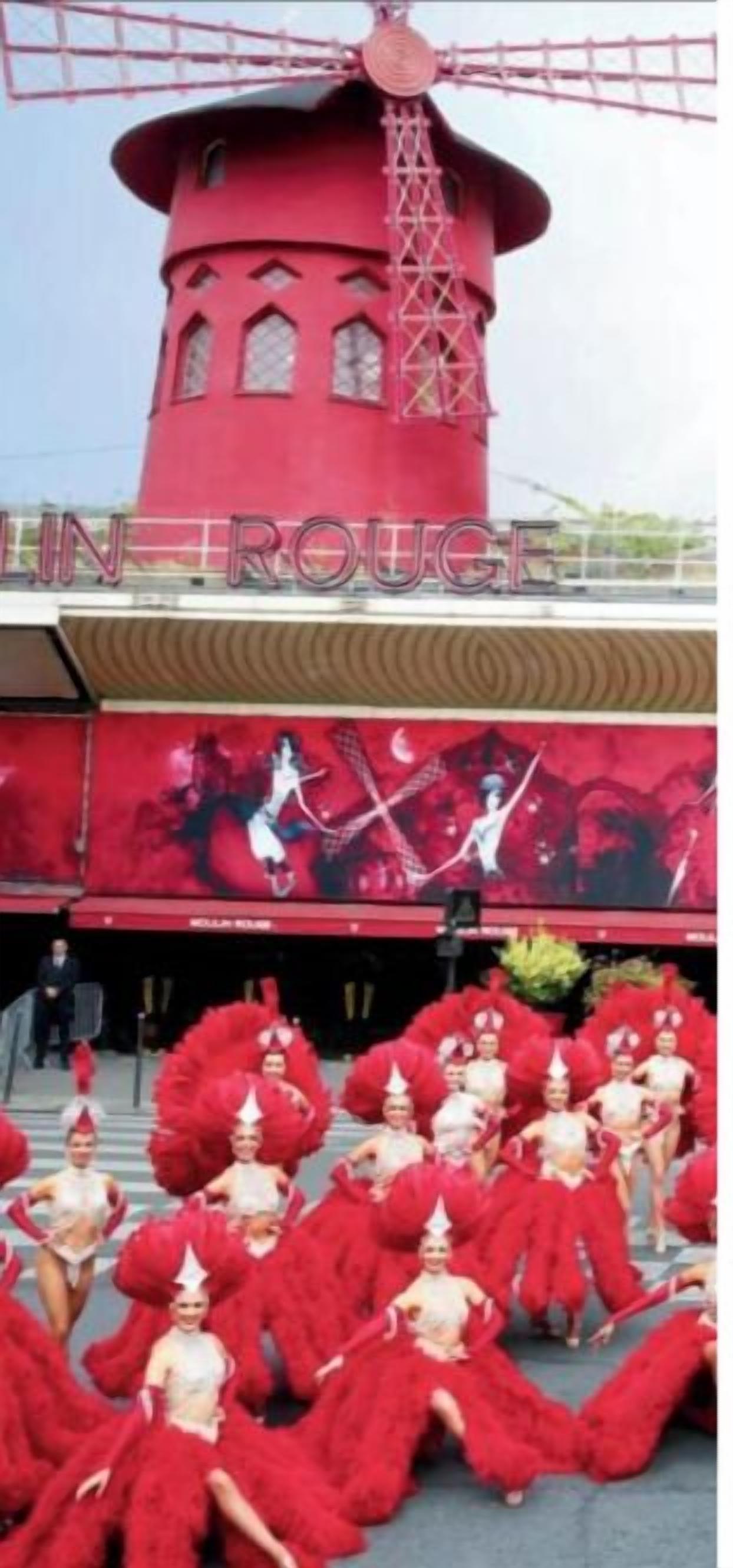 Un moulin à vent rouge avec l’inscription « EN ROUTE » sur un bâtiment.