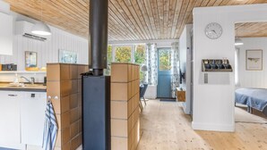 A modern kitchen with a central stove, wooden ceiling, and white cabinetry. - "Catha" - 200m from the sea by Interhome (Væggerløse)