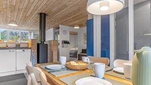 A modern kitchen with wooden cabinets, a built-in stove, and a dining area with a table set for two. - "Catha" - 200m from the sea by Interhome (Væggerløse)