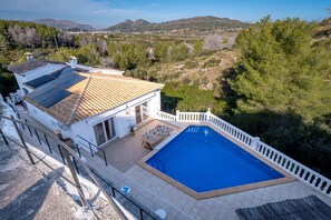 Eine Villa mit Schwimmbad, Solaranlage und Blick auf die umliegende Landschaft.