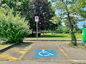 Ein Parkplatz mit Parkplatz für Behinderte Schild und Rollstuhlsymbol auf dem Boden.