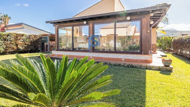 A modern house with large glass windows, a well-maintained lawn, and a stone pathway. - Frank's House, a villa surrounded by greenery with a private pool (Piana Calzata)