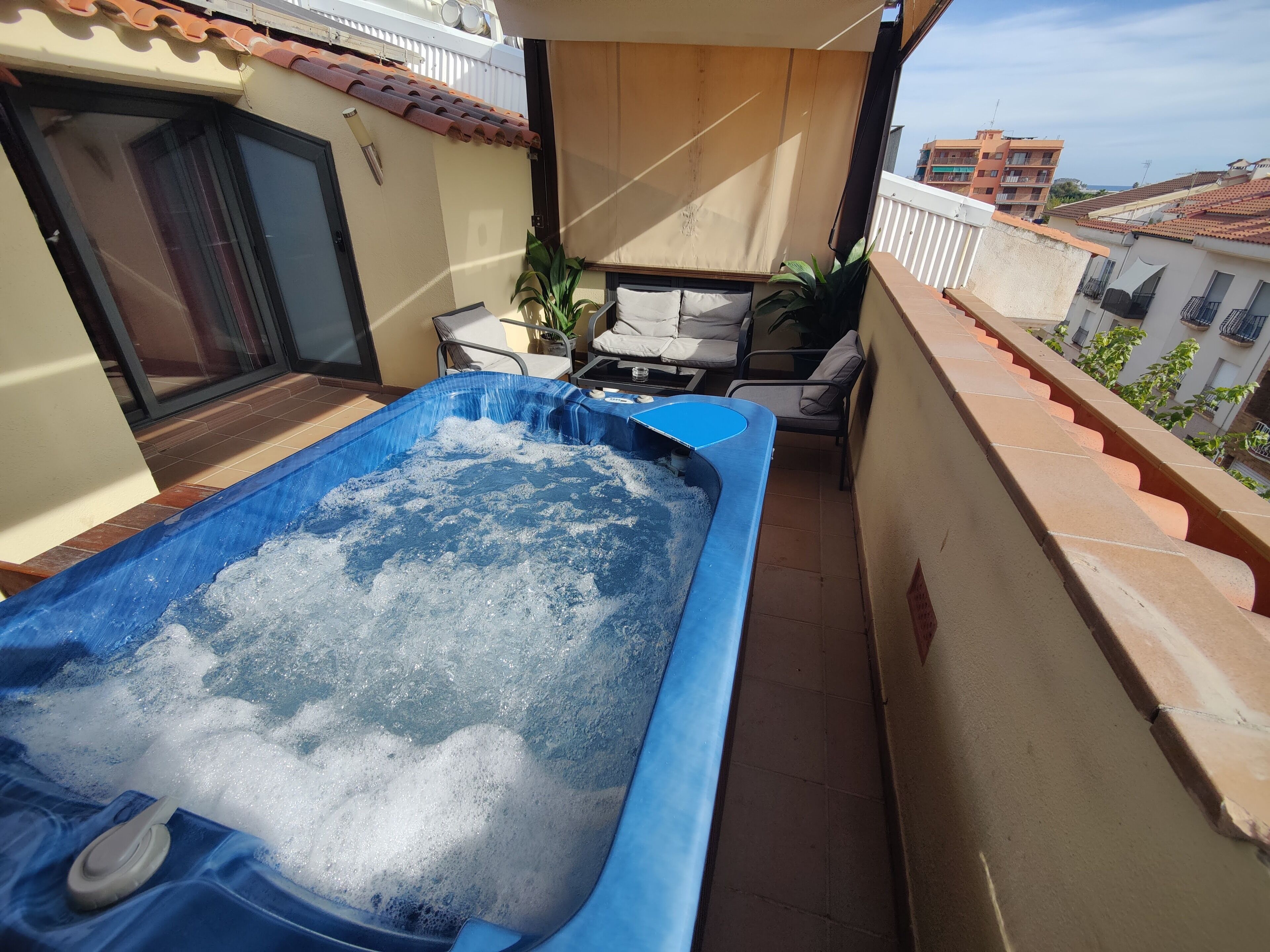 Un jacuzzi sur un balcon avec vue sur la ville.