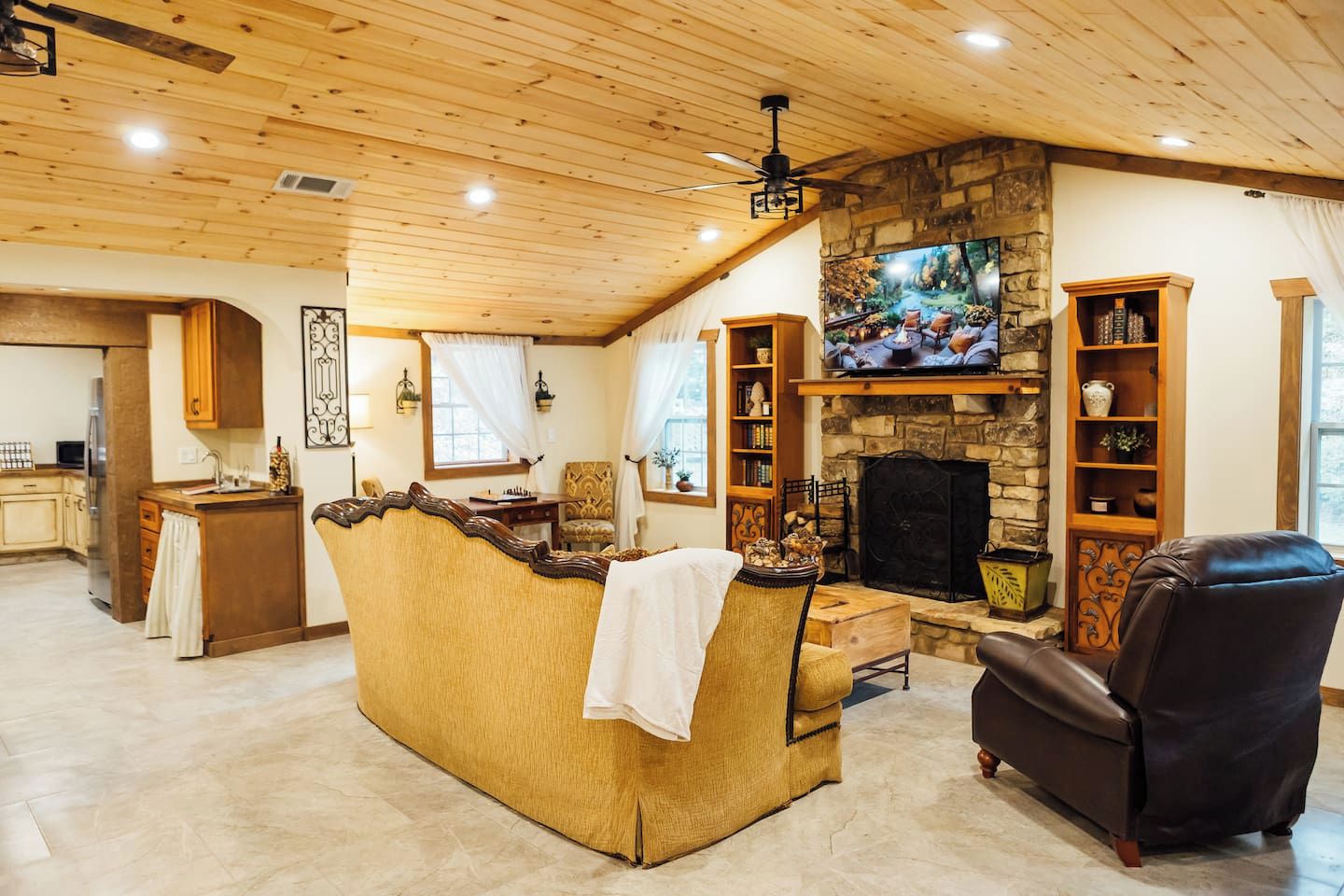 Una sala de estar acogedora con chimenea de piedra, un televisor y un espacio de estar cómodo.