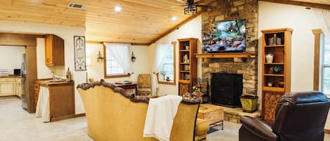 Una sala de estar acogedora con chimenea de piedra, un televisor y un espacio de estar cómodo.