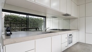Una cucina moderna con un'ampia finestra, mobili bianchi e forno integrato.