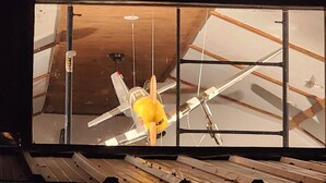 Une pièce dotée d’un plafond en pente, de poutres apparentes et d’une fenêtre donnant sur l’intérieur.