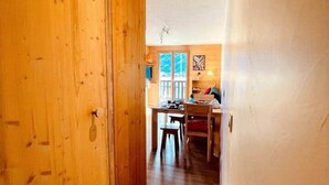 A wooden interior hallway leading to a dining area with a table and chairs. - Appartment 4 people - Cîmes Scolette (Aussois)