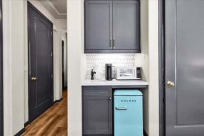 A narrow kitchen with dark cabinets, a microwave, and a Galanz refrigerator. - Legacy Hideaway C | Studio Legacy Villa (La Quinta)
