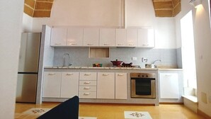 A kitchen with white cabinets, a built-in oven, and a tiled backsplash. - Dimora San Felice - Il Mandorlo (Gallipoli)