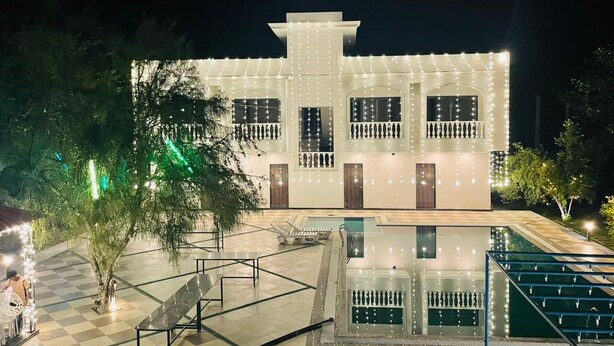 A modern building with a pool, surrounded by a checkered floor and trees. - Skyye Nature Resort (Malakhera)