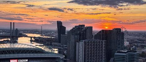 Un paisaje urbano con un estadio y edificios modernos al atardecer.