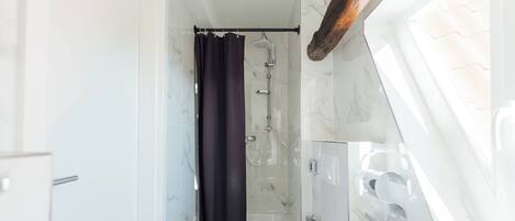 Ein kleines Badezimmer mit Badewanne, Toilette und Dusche.