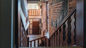 Un escalier avec une rampe en bois et un mur en briques.