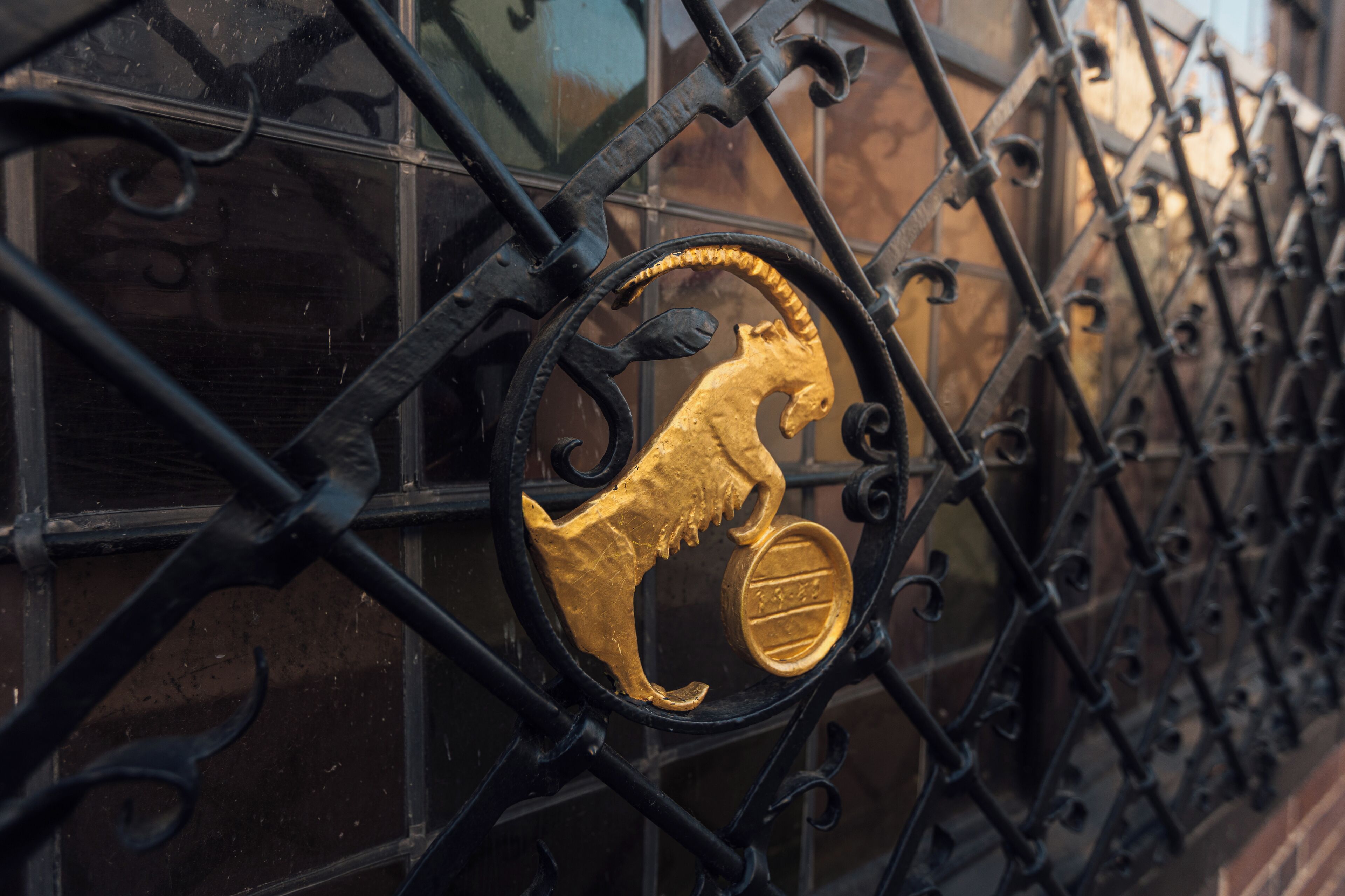 A wrought iron gate with a golden lion emblem.