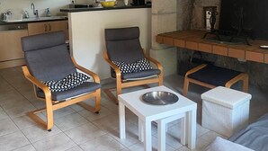 A modern kitchen with wooden cabinets, a built-in stove, and a dining area with two chairs and a small table. - Former Farm in the Loire Gorges—classified as a 3-star vacation rental (Vorey)