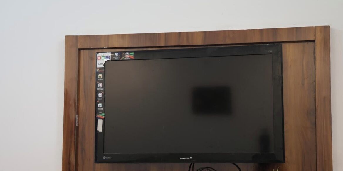 Een flatscreen televisie bevestigd aan een houten muur.