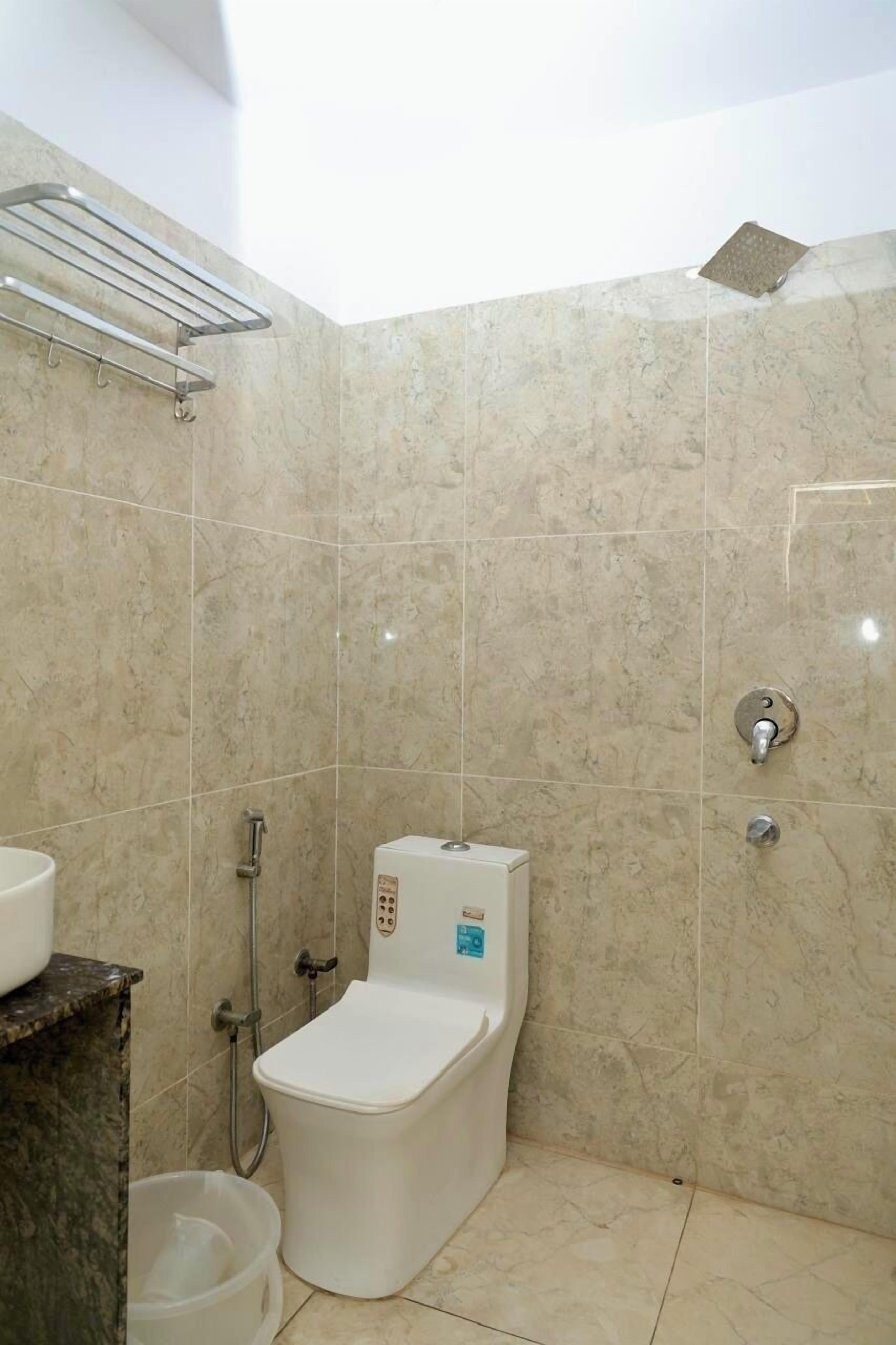 A bathroom with a toilet, a shower, and a sink.