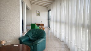 A spacious room with a green leather sofa, a wooden table, and a dining area with a green chair and a wooden table. - Bright, quiet loft within walking distance - Exceptional location (Le Gosier)