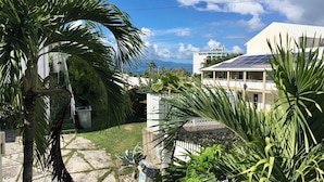 A residential area with a white house, a paved pathway, and a palm tree. - Bright, quiet loft within walking distance - Exceptional location (Le Gosier)