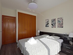 A hotel room with a large bed, a wardrobe, a bedside table with a lamp, and three wall-mounted artworks. - Diamonds Sea View – Apartamento frente al mar con terraza y capacidad para 6 personas (Lloret de Mar)