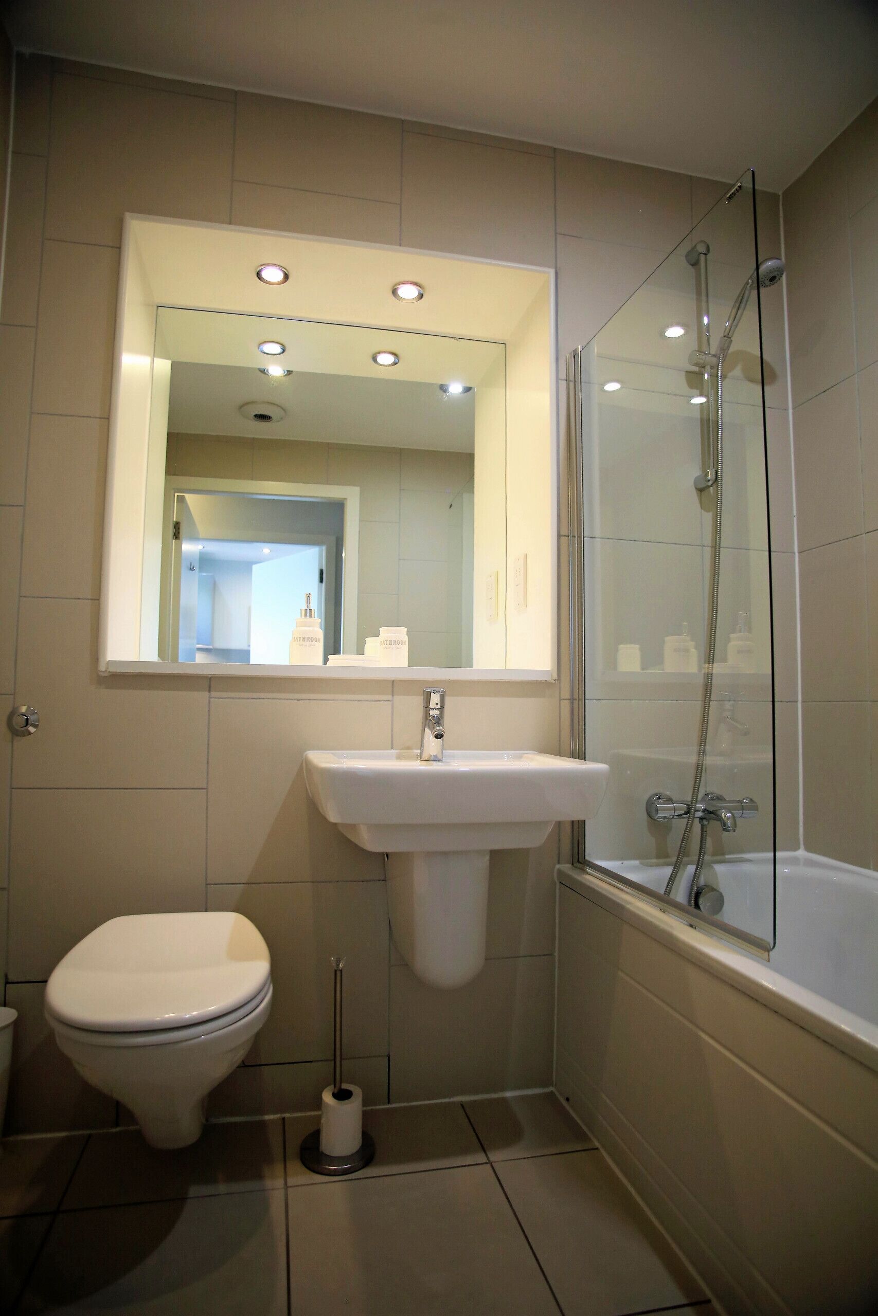A bathroom with a toilet, sink, and glass-enclosed shower.