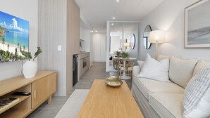 Ein modernes Wohnzimmer mit einer Couch, einem Couchtisch und einem Essbereich mit Tisch und Stühlen.